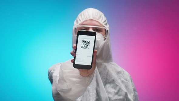 Woman Doctor Wearing Protective Uniform Showing on Phone Vaccination Passport with Qr Code