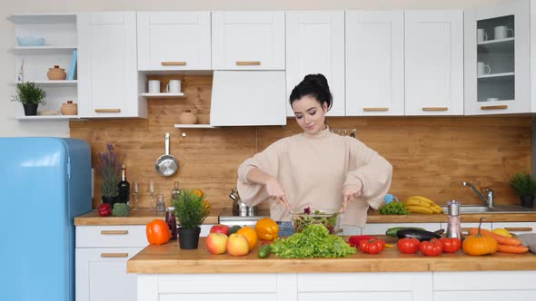 Young Brunette Woman Cooking Healthy Vegan Salad At Home