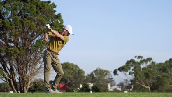 Golf player hitting the ball with his club