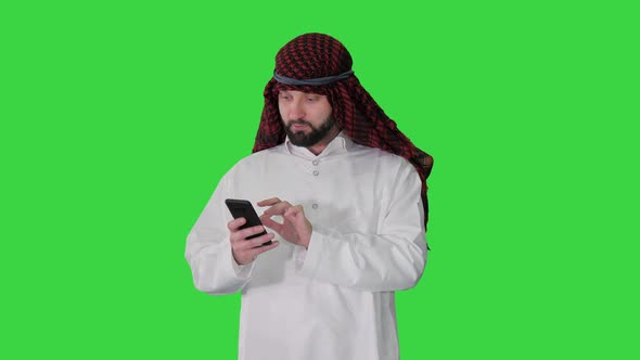 Arab Sheikh Wearing Keffiyeh Receiving Grate News on the Phone on a Green Screen Chroma Key