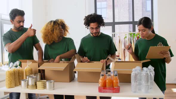 Happy Volunteers Packing Food in Donation Boxes