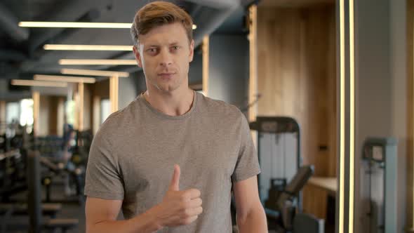 Confident Fitnessman Showing Thumb Up in Sport Club. Sportsman Standing at Gym