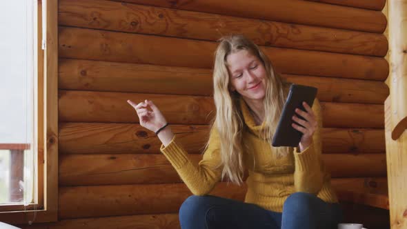 Caucasian woman spending time at home, using a tablet and smiling