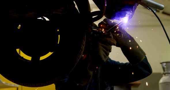 Mechanic using wielding torch on a car 4k