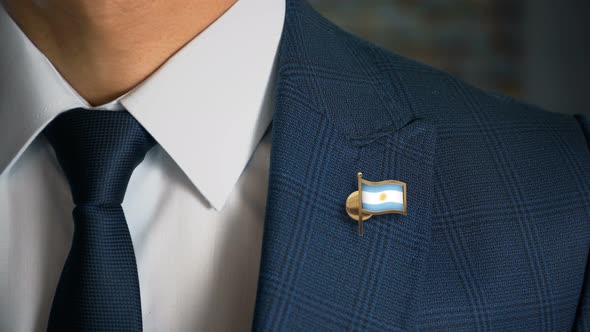 Businessman Walking Towards Camera With Country Flag Pin   Argentina