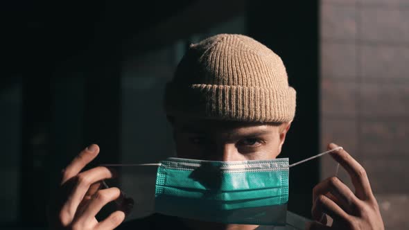 Portrait of a Young Caucasian Man Putting on a Protective Mask. Concept of Health and Safety Life