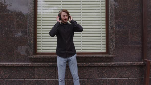 A Man Enjoys Listening to Music on Headphones