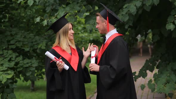 Happy Male and Female Graduates Chatting About Future in Park, Graduation Day