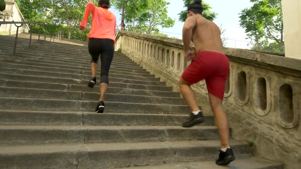 A couple running on stairs in a city as a workout