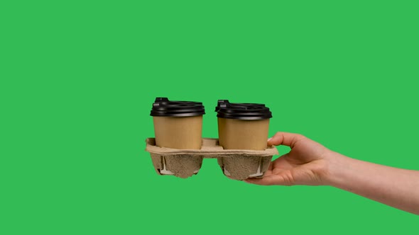Female Hand Gives Set of Paper Cups with Hot Coffee or Tea