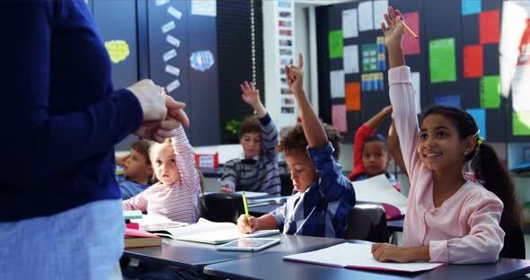 Schoolkid raising their hands in classroom