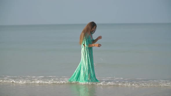 Woman in a Bathrobe Walking Along the Sea