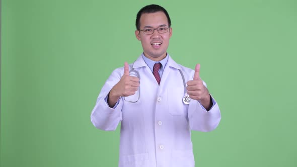 Happy Asian Man Doctor with Eyeglasses Giving Thumbs Up and Looking Excited