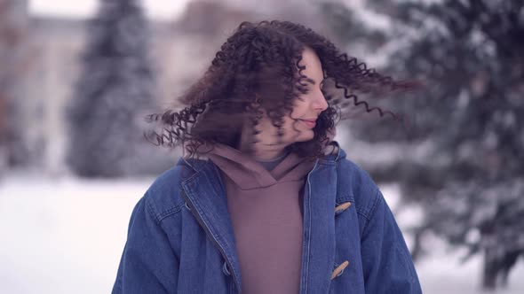 Happy Young Woman with Afro Curls in a Winter City