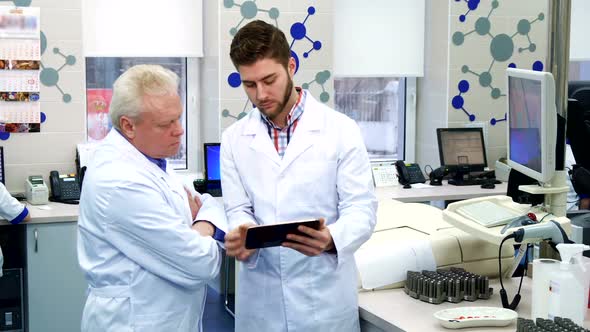 Man Shows Something on Monitor To His Colleague at the Laboratory