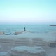 Woman Walks Along the Coastline on the Rocks - VideoHive Item for Sale