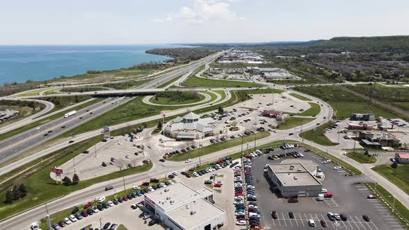 Aerial backwards shot showing traffic on highway and parking cars at market near Grimsby Town in Can