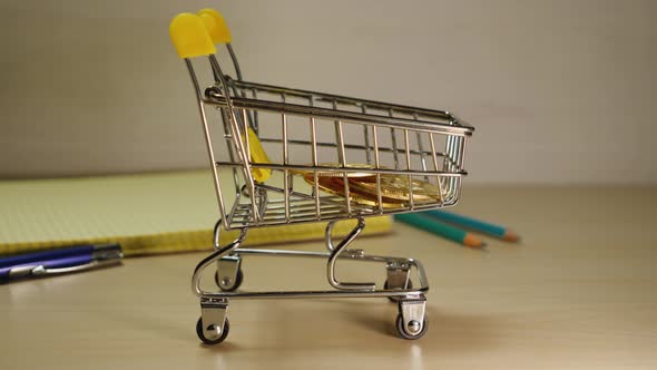 Close-up of male fingers stacking Bitcoin cryptocurrency coins in a shopping cart