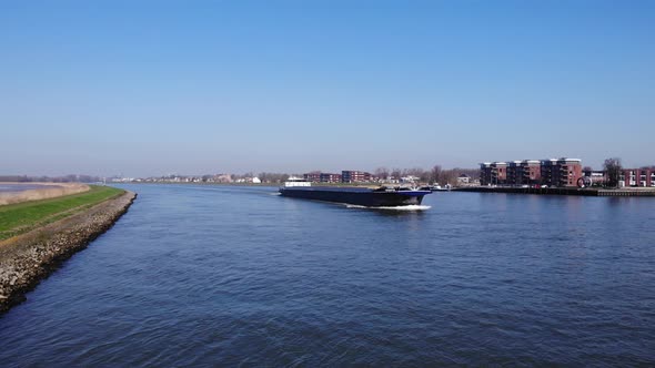 Large Cargo Vessel Sailing Downstream On River Noord In South Holland, Netherlands. - Aerial Shot