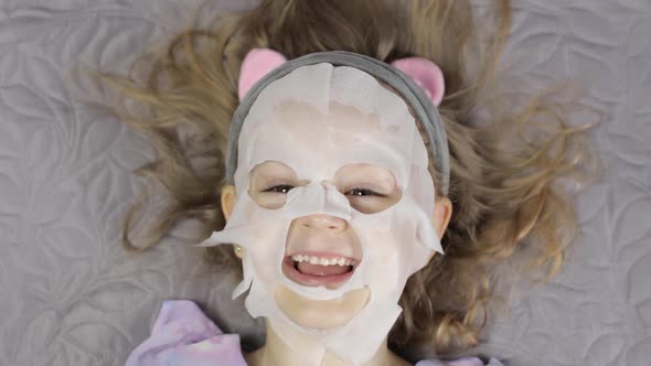 Teen Girl Applying Moisturizing Face Mask. Child Kid Take Care of Skin with Cosmetic Facial Mask