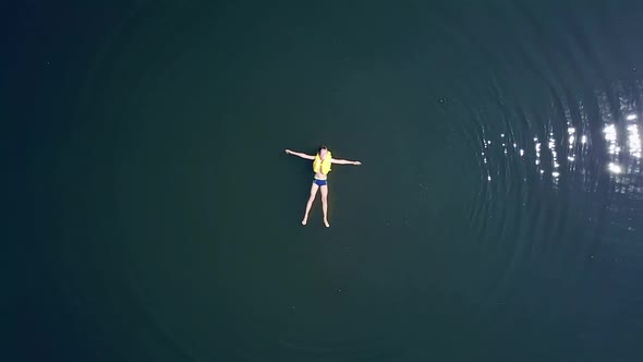 Boy swimming in river. Aerial drone bird eye view of boy relaxing in river