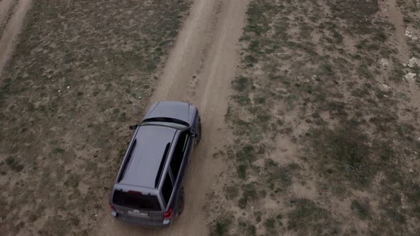 Top View Aerial Tracking Shot Suv Automobile Riding on Field of Mountain Cliff Over Beach Sea