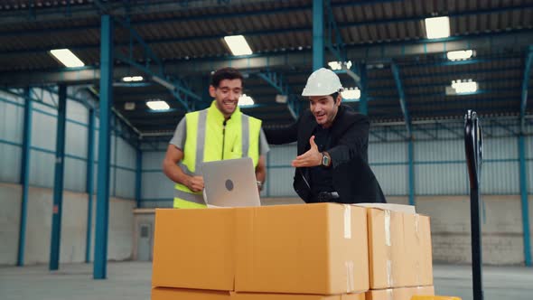 Two Factory Worker Celebrate Success Together in the Factory