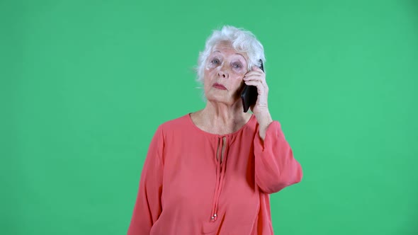 Portrait Elderly Woman Looking at the Camera and Talking on Her Smartphone