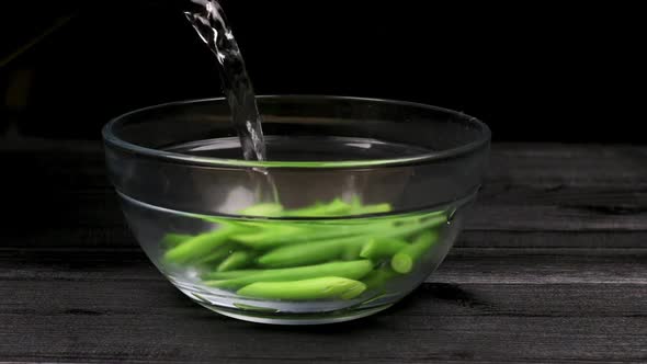 Boiling Water is Poured into Bowl with Garlic Shoots