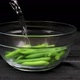 Boiling Water is Poured into Bowl with Garlic Shoots - VideoHive Item for Sale