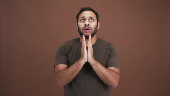 Nervous Eastern Guy Praying to God Making Cherished with Waiting for Positive Result Brown Studio