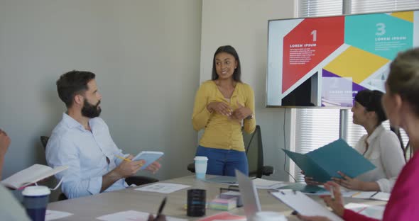 Diverse male and female business colleagues discussing at meeting in office