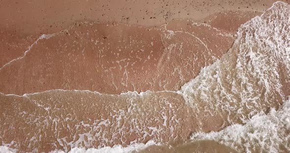 Top Down View of Waves Breaking in the Sand, Flying Over Tropical Sandy Beach and Waves