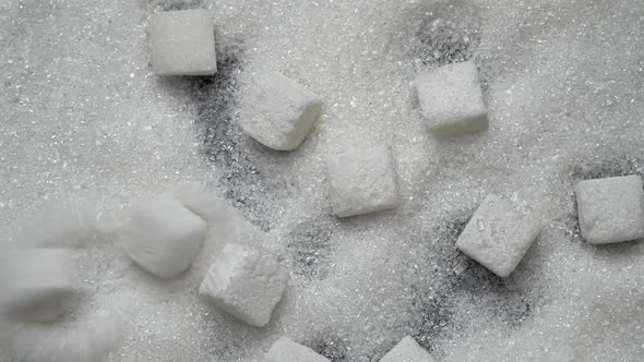 White Sugar Cubes Fall on Granulated Sugar