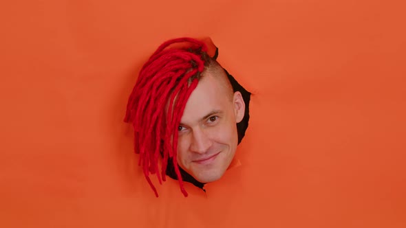Young Man Sticking Out of Hole of Orange Background