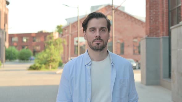 Close Up of Man Walking Towards Camera in Street Slow Motion