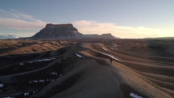 Person jogging on top of sand dune in the Utah desert