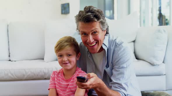 Father and son watching television in living room 4k