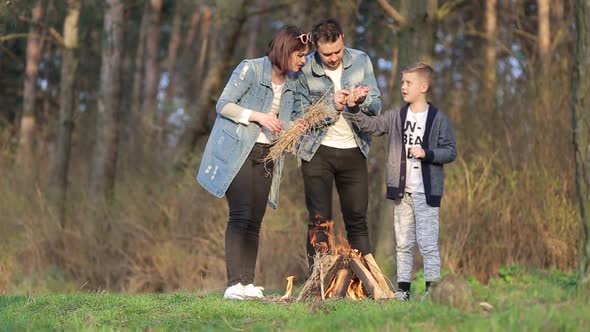 Happy family concept. Young mother and father kissing their daughter in the park.