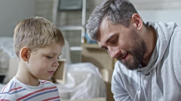 Proud Father Praising Son for Assembling Shelf