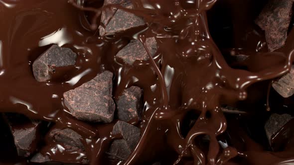 Super Slow Motion Shot of Raw Chocolate Chunks Falling Into Melted Chocolate at 1000 Fps alt