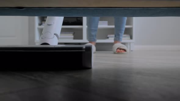 Woman Cleaning Living Room with Modern Upright Vacuum Cleaner  Point of View