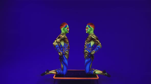 Portrait Of Young Guys In Uv Paint. Twins Faces And Body In The Dark Under The Light 