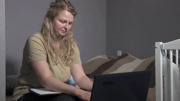 Self-isolation of family life. Mom works at home with a laptop, distracted by her child.