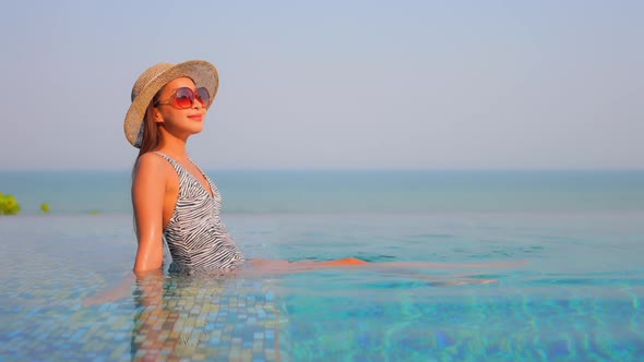 Young asian woman enjoy around outdoor swimming pool for leisure