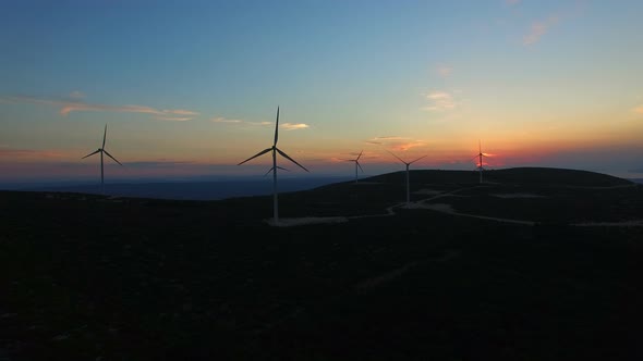 Aerial view of white elegant windmills at sunset