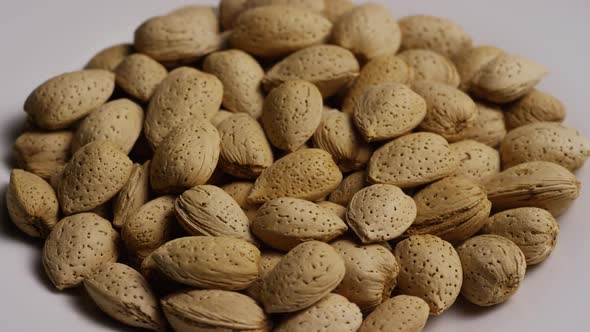 Cinematic, rotating shot of almonds on a white surface - ALMONDS