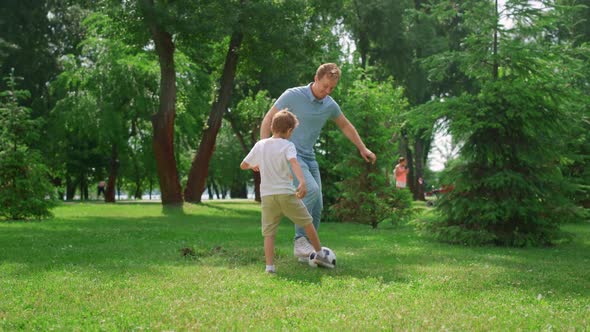 Happy Father Teaching Son Play Soccer