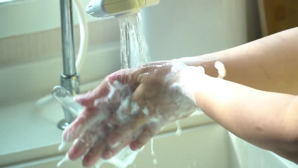 Hands Of Woman Wash Their Hands In A Sink With Foam