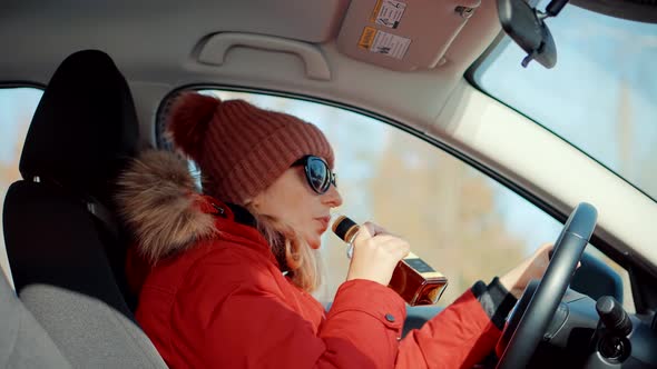 Drunken Driving Risk Car Accident.Woman Holding Alcohol Bottle In Car.Dangerous On Road Drunk Driver